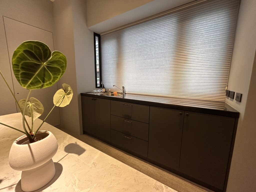深色廚具搭配雙色蜂巢簾，呈現色彩與材質搭配